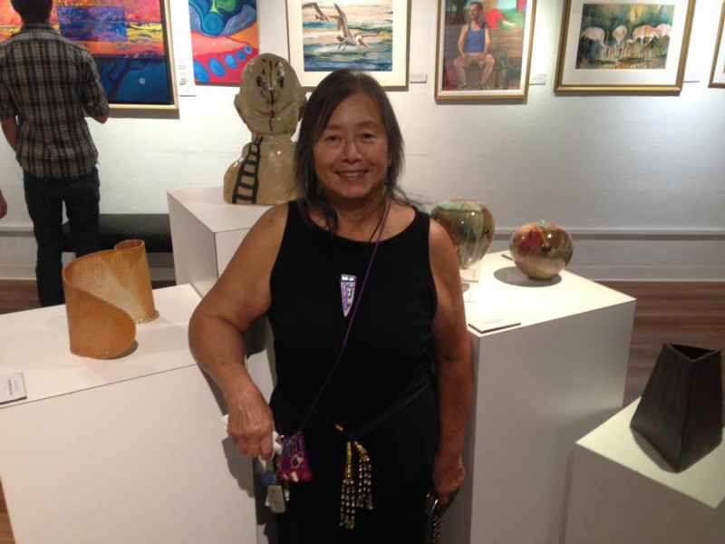 Mavis Jan-Lai and her two ceramic vessels at the Art Center Manatee. Her works are the one on her right and the hand built piece on her left!